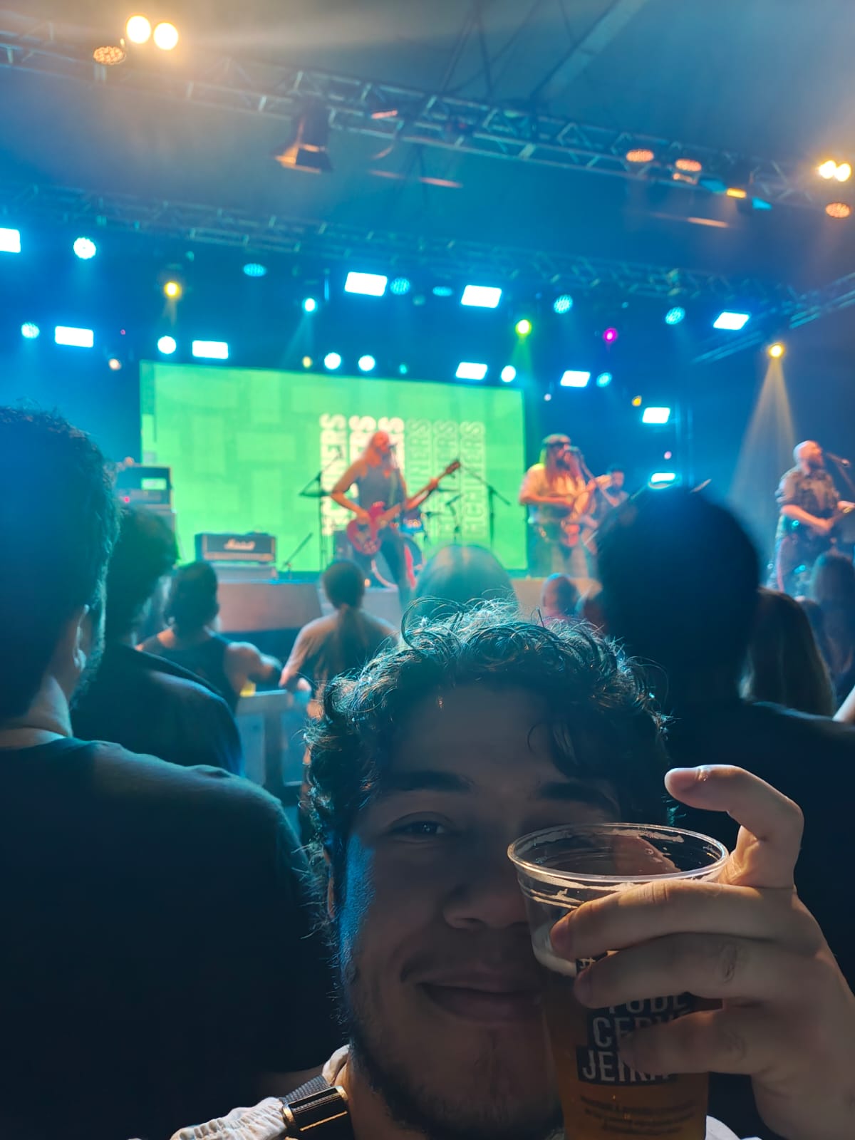 Me smiling and raising a cup of beer at a McMiners concert